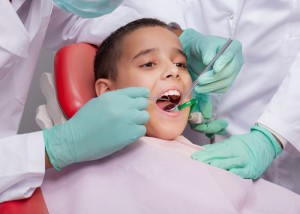 Close up of boy having his teeth examined by a dentist